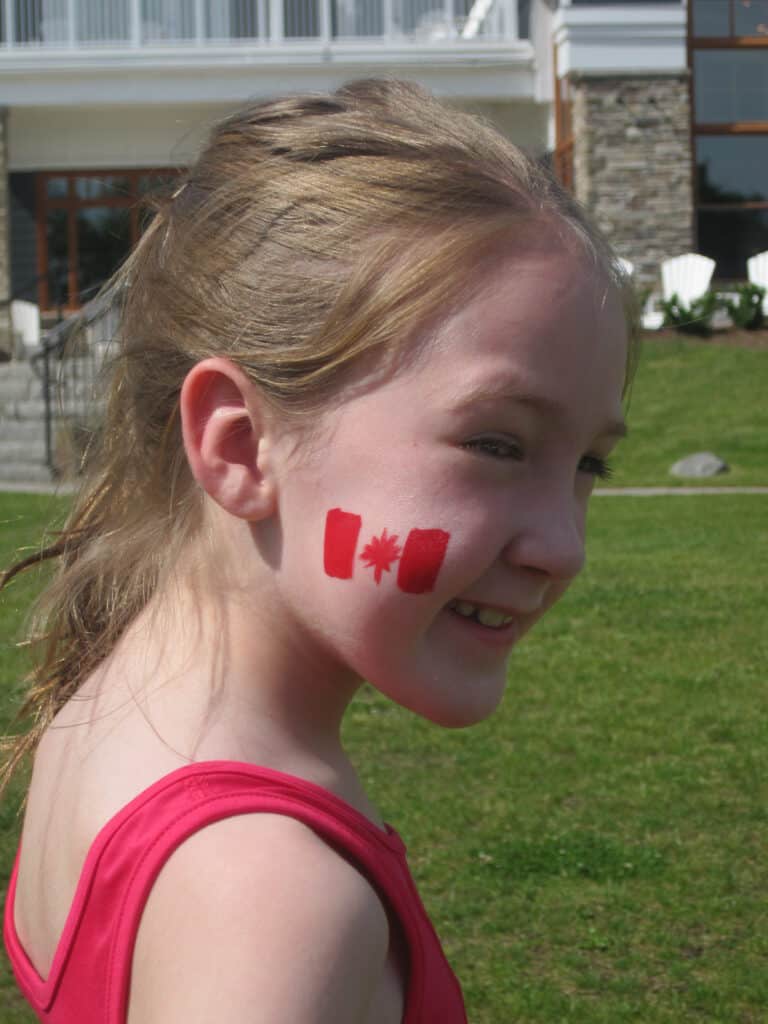 young girl in red tank top with canada flag painted on cheek - rosseau muskoka resort.