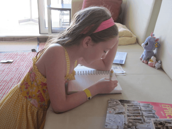 Child writing in travel journal