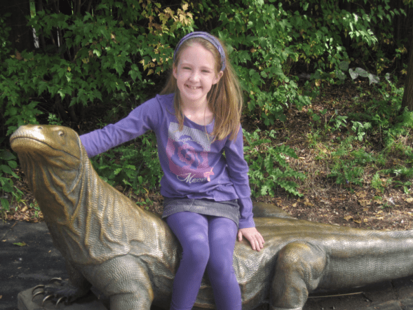 girl on komodo dragon statue at Toronto Zoo