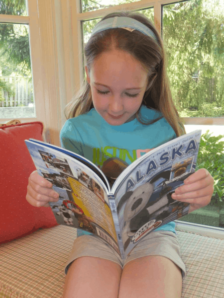 Emma reading her Cooper's Guide for Alaska