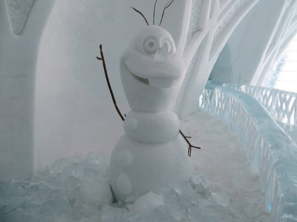 Olaf the Snowman from Disney's Frozen beside the Grand Slide - quebec ice hotel.
