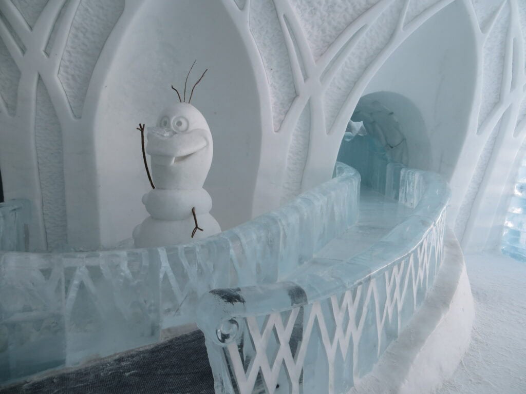 quebec ice hotel - ice slide with olaf from disney's frozen beside.
