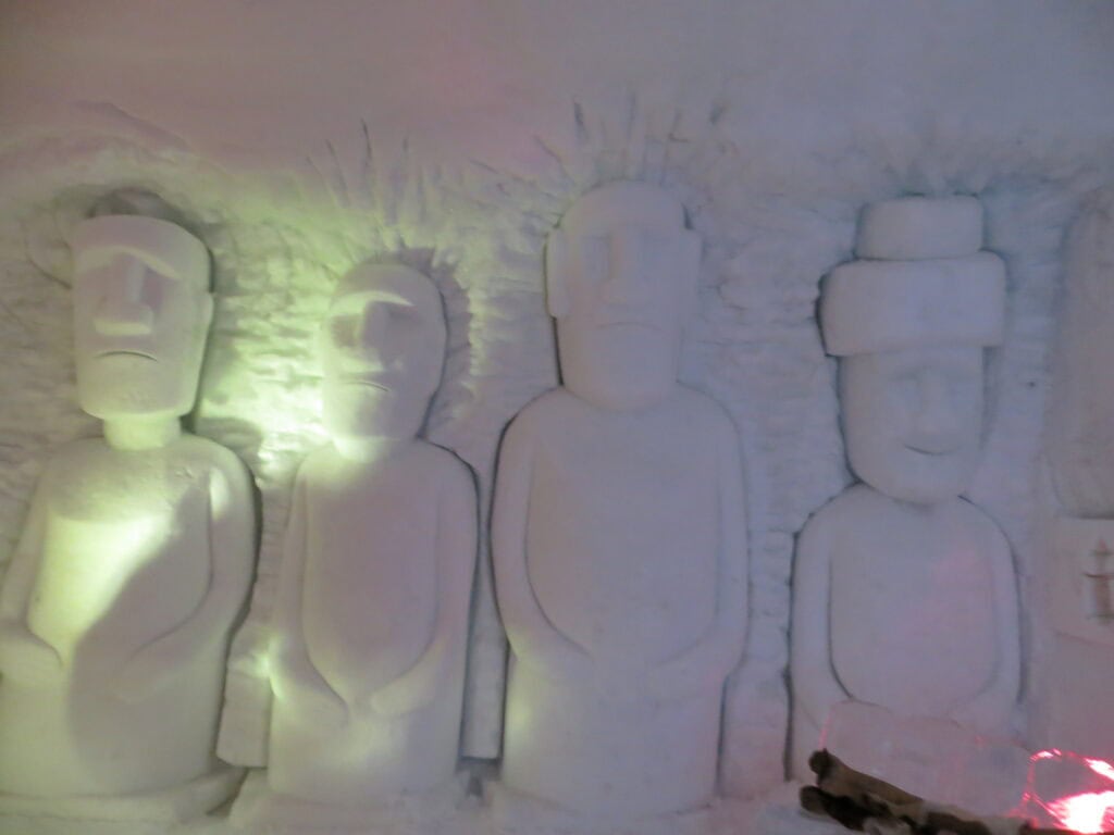 quebec ice hotel - suite with carving of easter island statues.