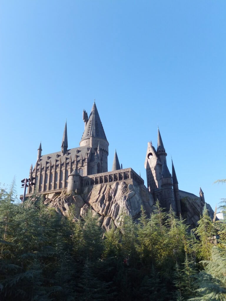 hogwarts castle at universal studios in florida set against bright blue sky.