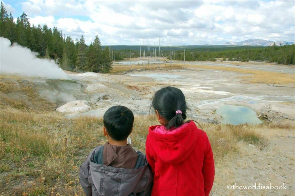 young children viewed from behind watching basin at Yellowstone National Park.
