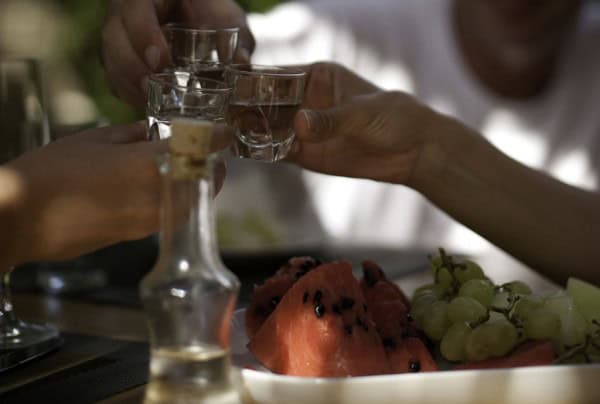 pouring small glass of raki - Crete - Greece.