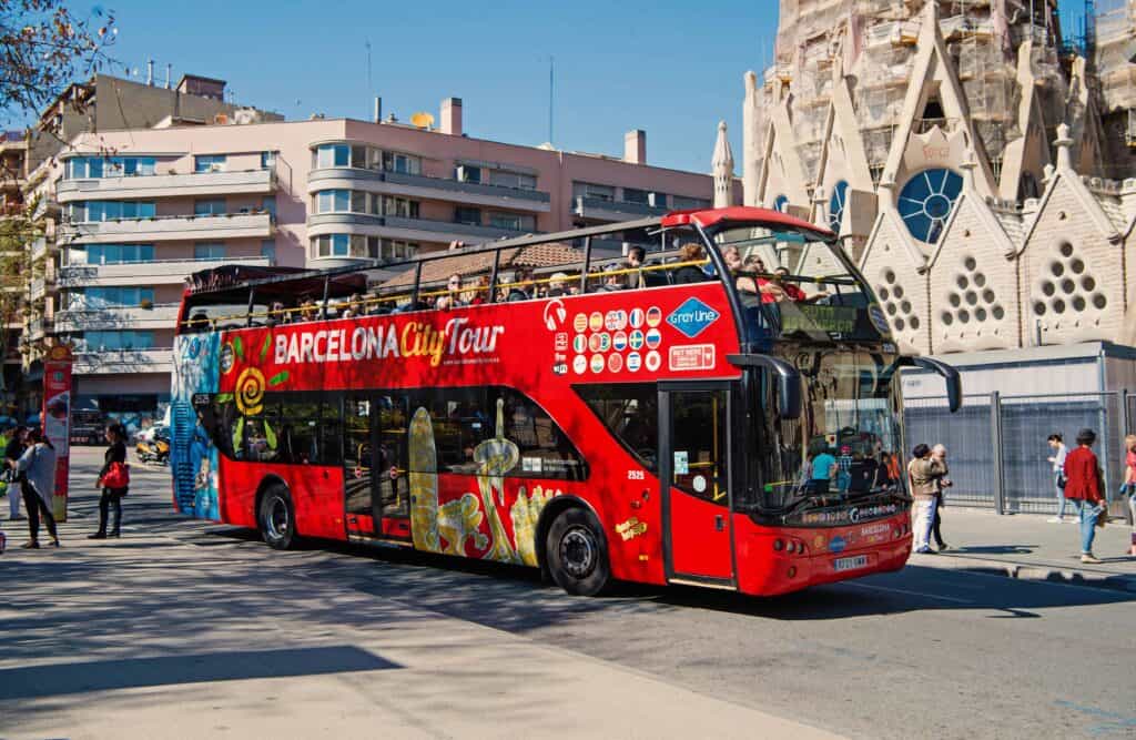 bright red double decker tour bus on street in Barcelona, Spain.