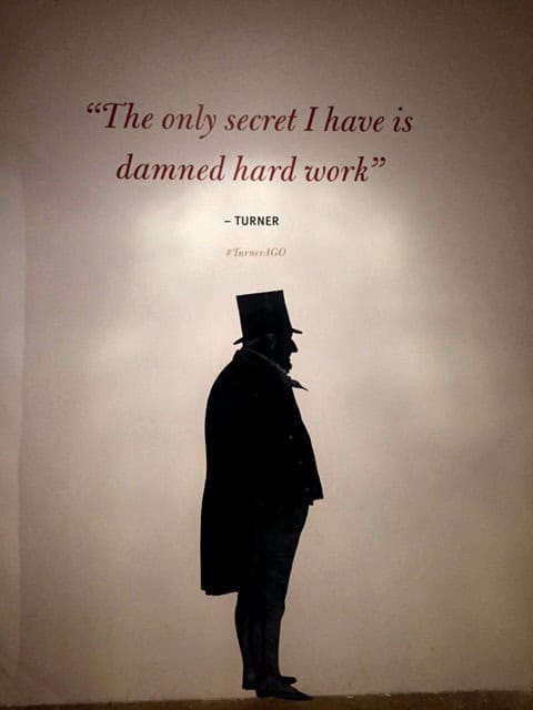 shadow of man on a wall with Turner quote "The only secret I have is damned hard work" at the AGO Turner exhibit.
