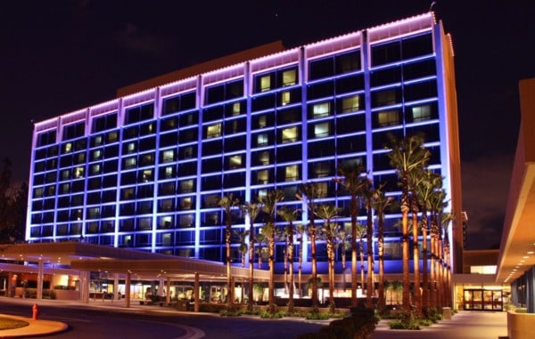 exterior of disneyland hotel lit up at night.