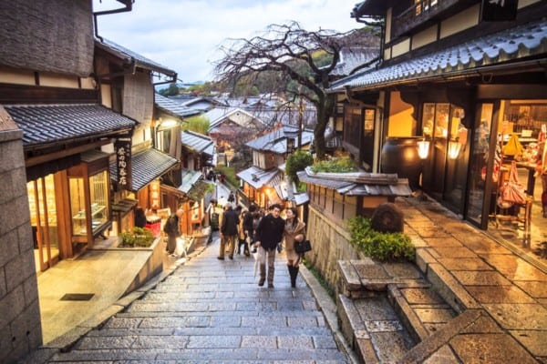 couple walking up hill on stone pavers - Kiyomizu Temple in Kyoto Japan.