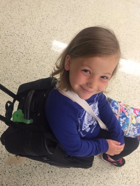 young girl riding on Lugabug travel seat in airport