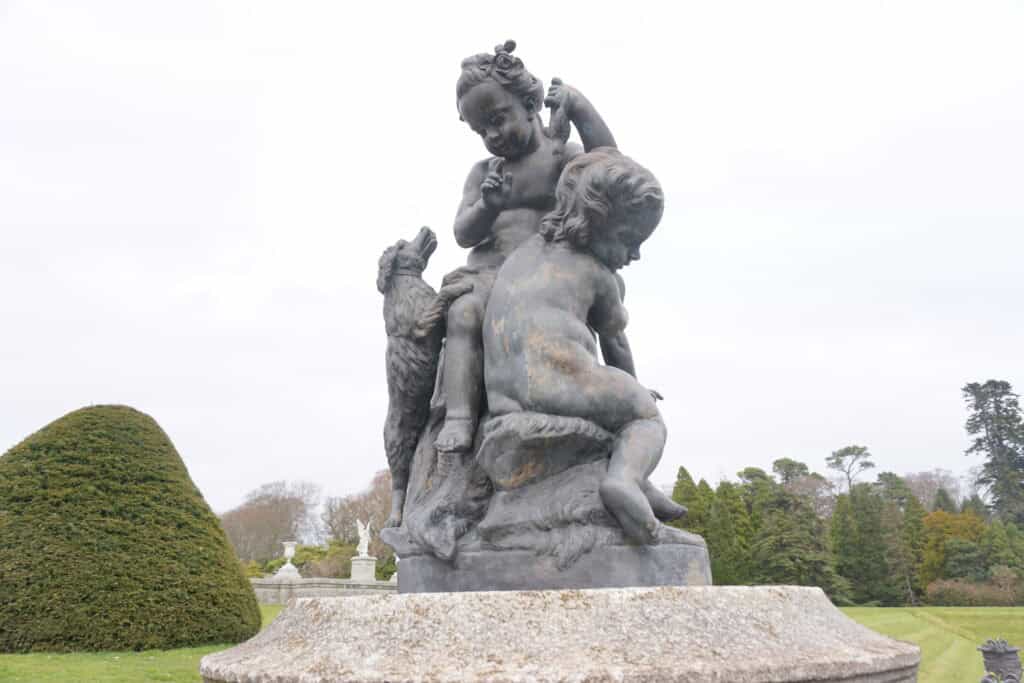 statue of two children and a dog climbing on a rock - Italian Garden at Powerscourt.
