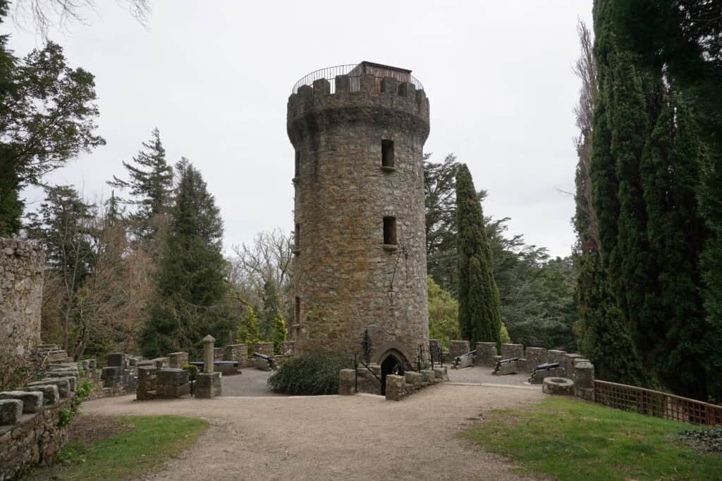 round stone tower with turrets and two window openings at Powerscourt gardens