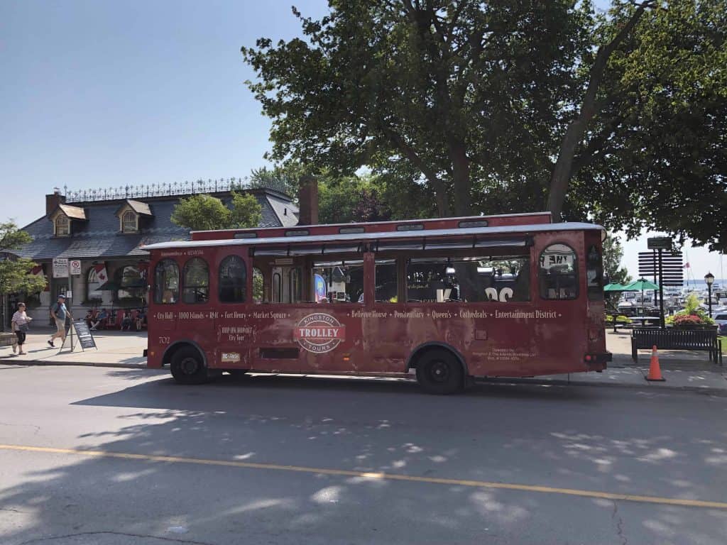 red trolley bus parked on street in Kingston