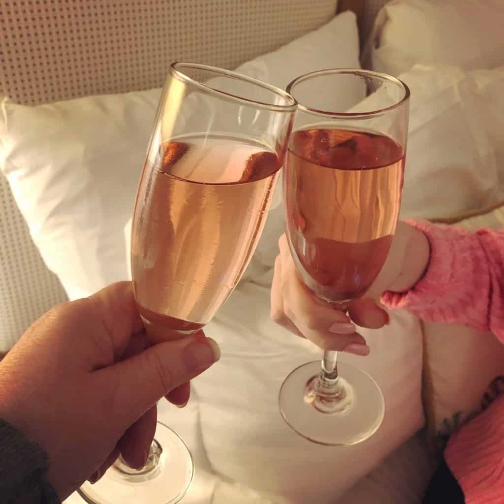 toasting with two glasses of pink champagne
