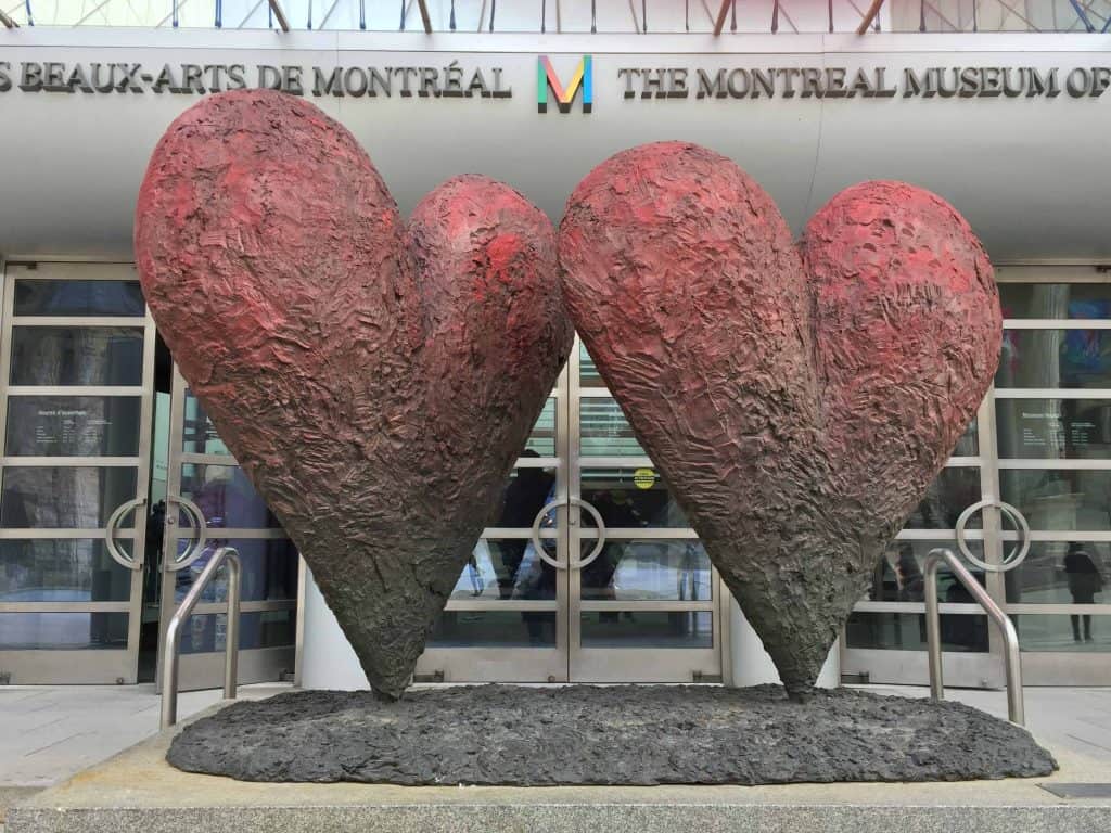 sculpture of two red hearts outside museum