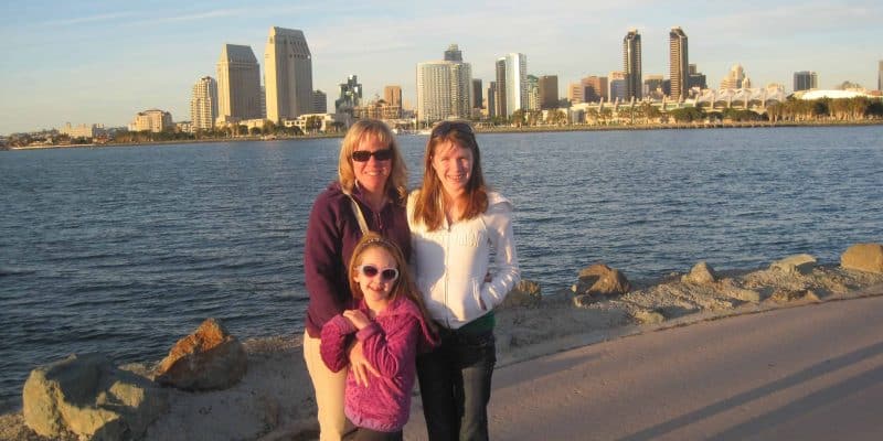 Family on coronado island with san diego skyline behind them