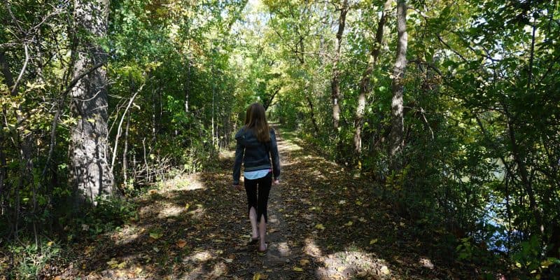 girl walking on wooded trail