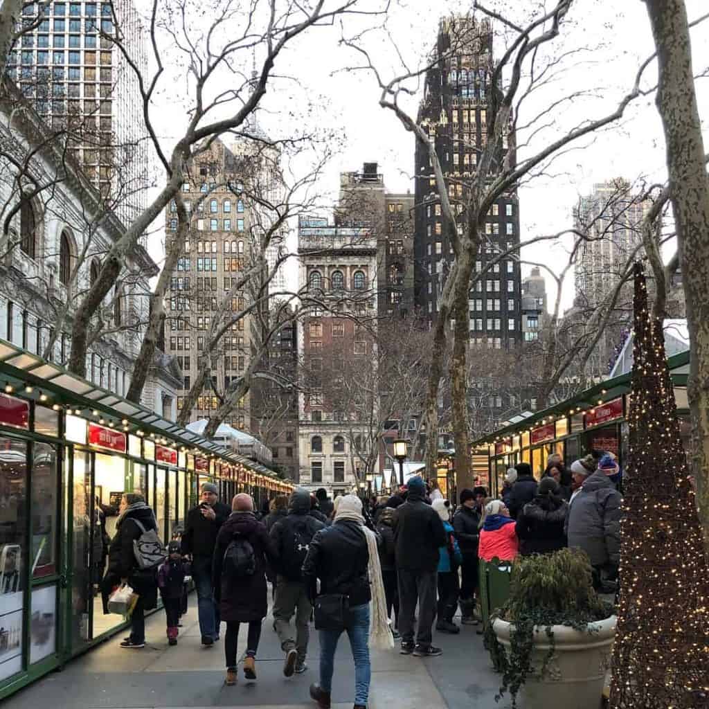 crowds shopping at outdoor holiday market in city
