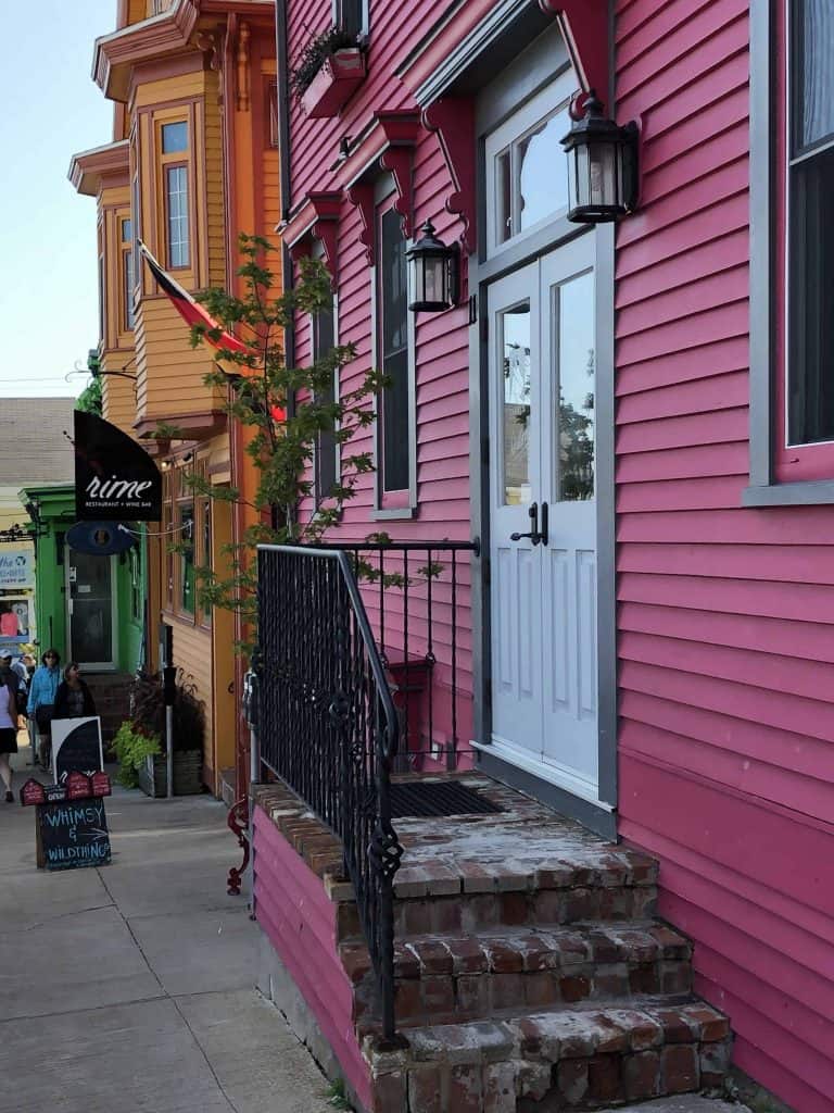 pink green and orange building fronts on street