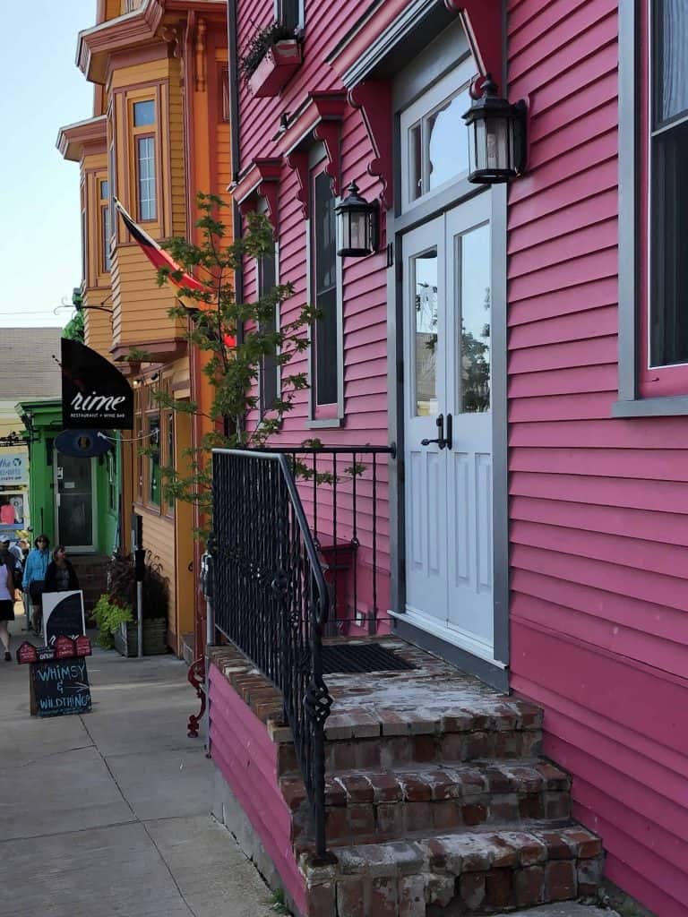 pink green and orange building fronts on street