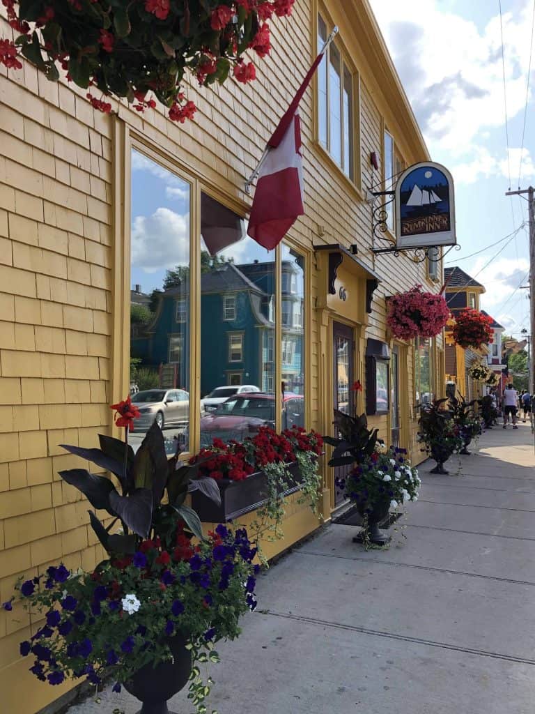 yellow wooden building with flowers and Rum Runner Inn sign