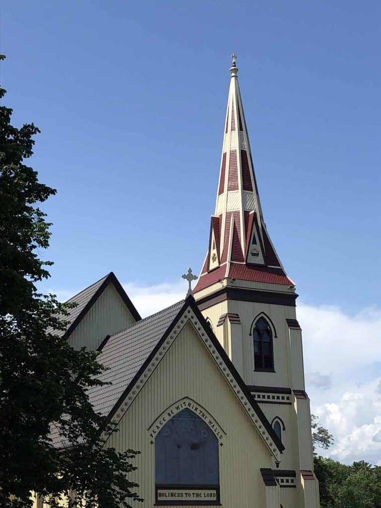 yellow and red wood church with blue sky background