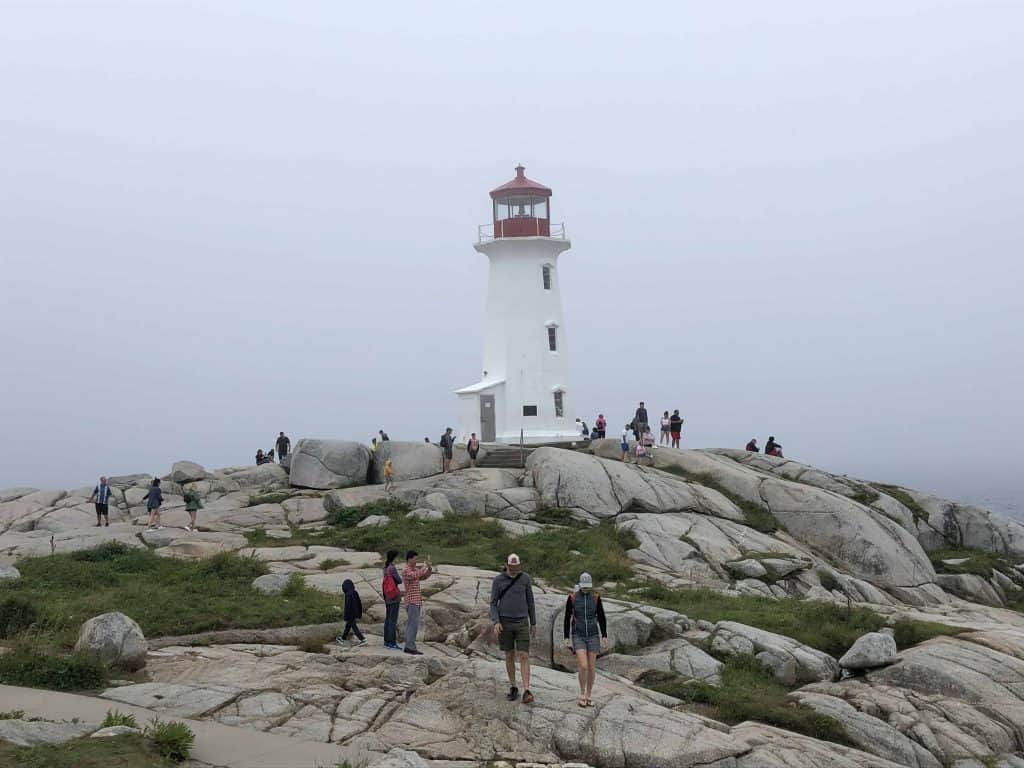 nova scotia lighthouse route-peggy's cove-red and white lighthouse on rocks with people around