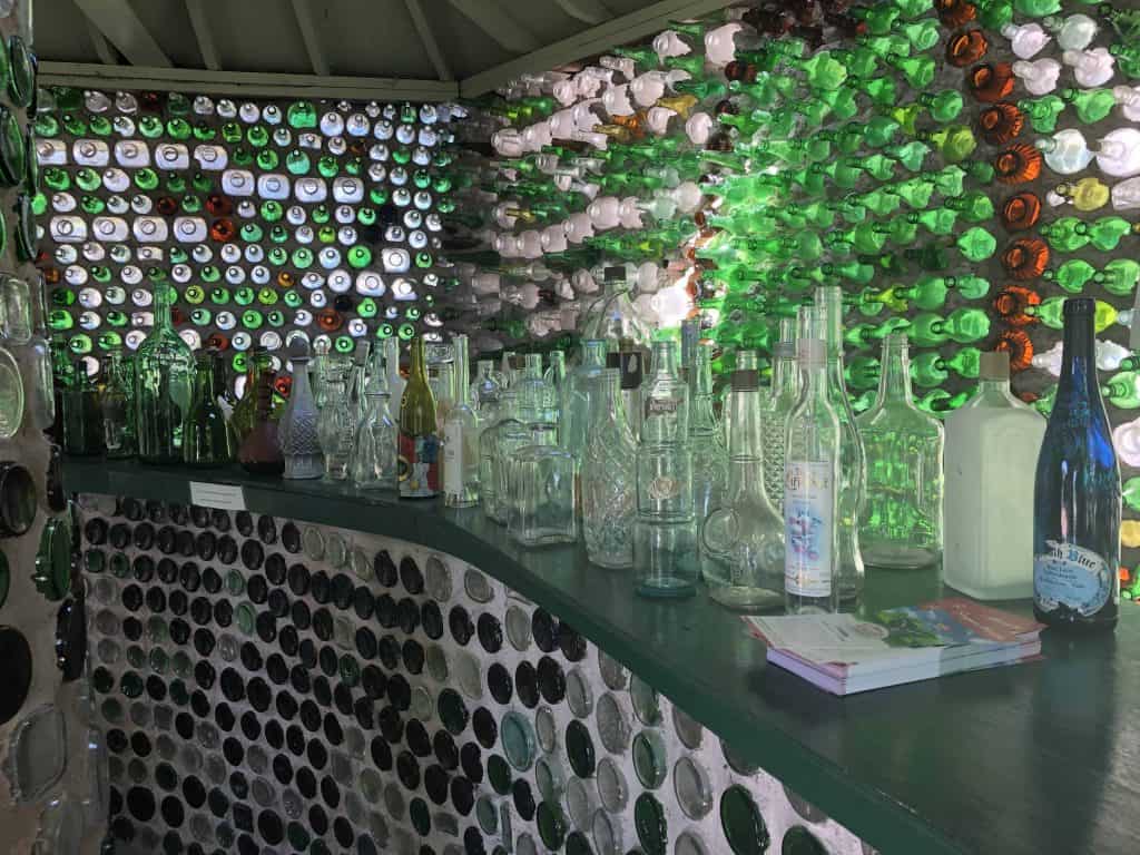 bar with empty bottles inside house made of bottles