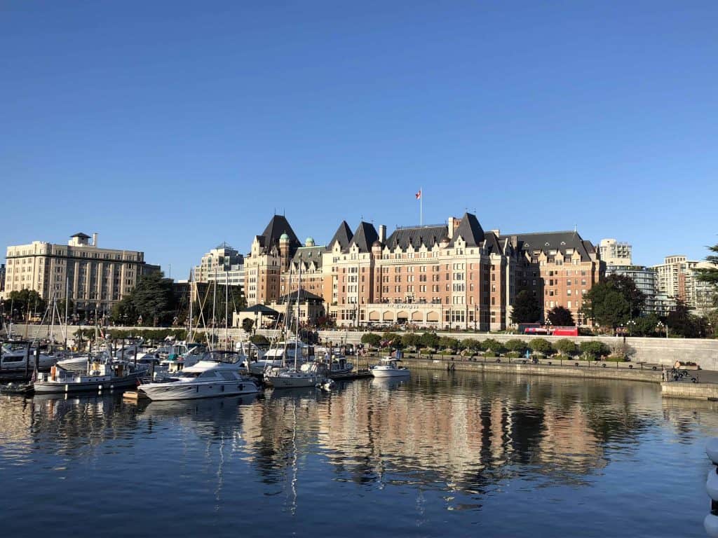 Inner Harbour in Victoria, British Columbia with boats in the water and Fairmont Empress in background and reflected in the water.