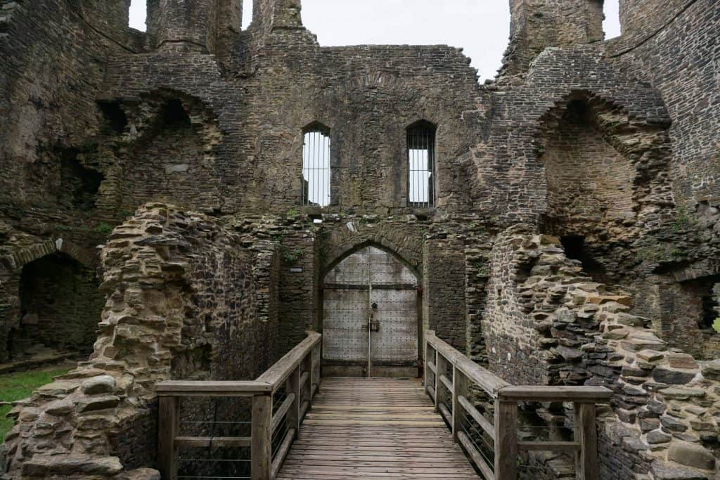 stone walls of ancient castle with wooden bridge and entrance door