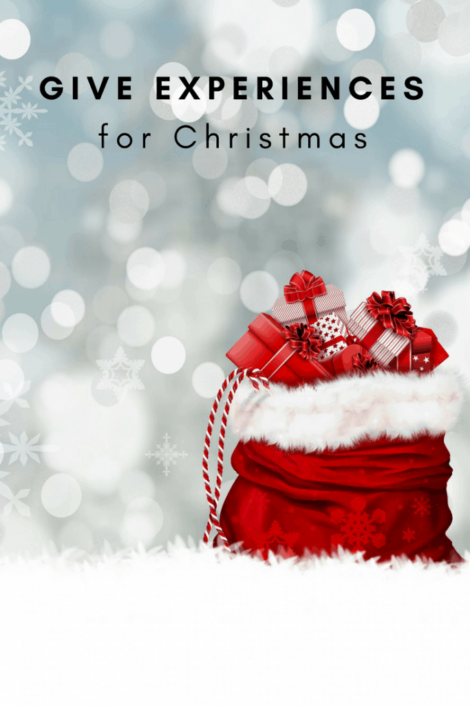 Image for Pinterest reading "Give Experiences for Christmas" with red bag with fur on top ful of red and white gift packages  against white background with snowflakes and bokeh effect.