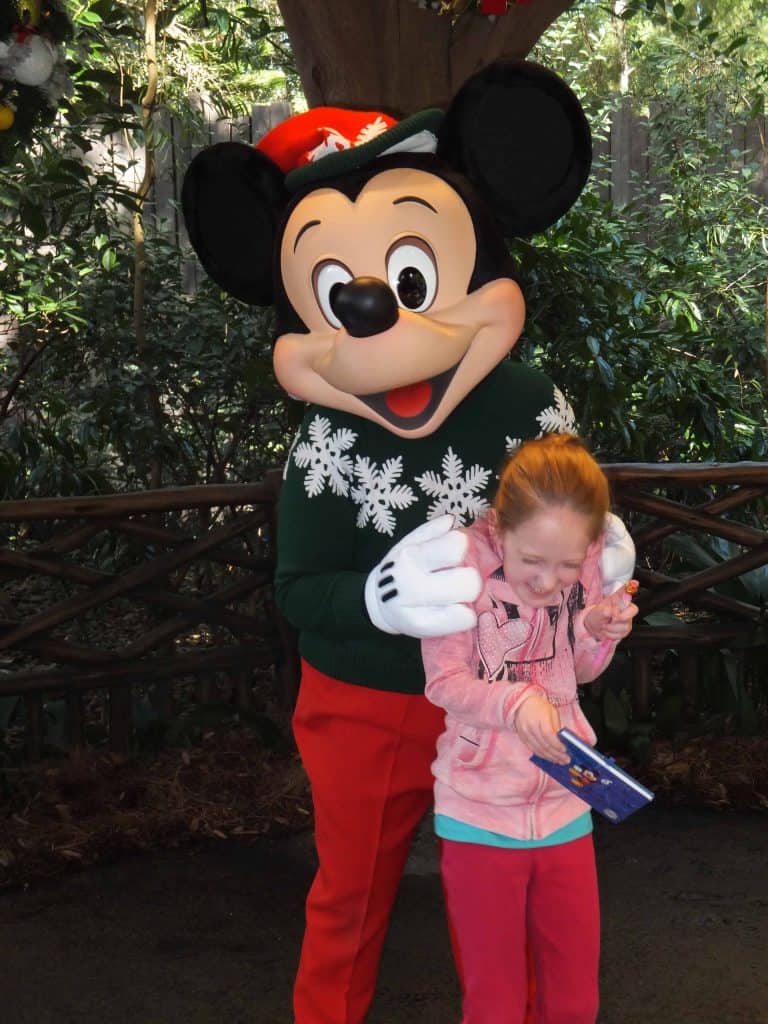 mickey mouse in red pants and green sweater tickling young girl