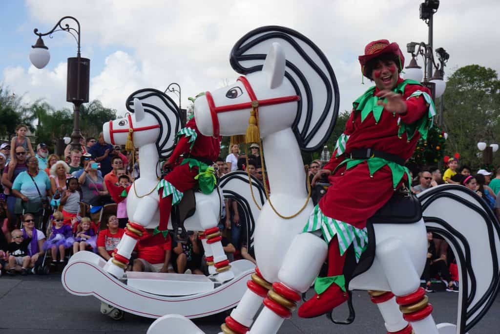 christmas characters on wooden rocking horses in disney parade