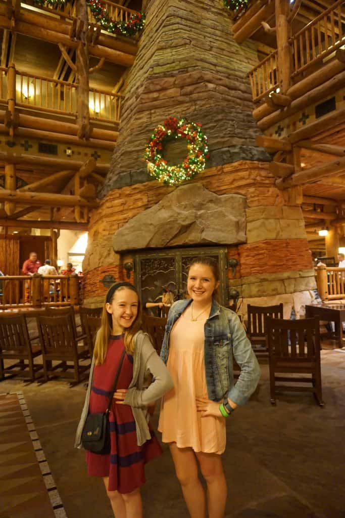 girls in lobby with large stone fireplace-disney wilderness lodge at christmas