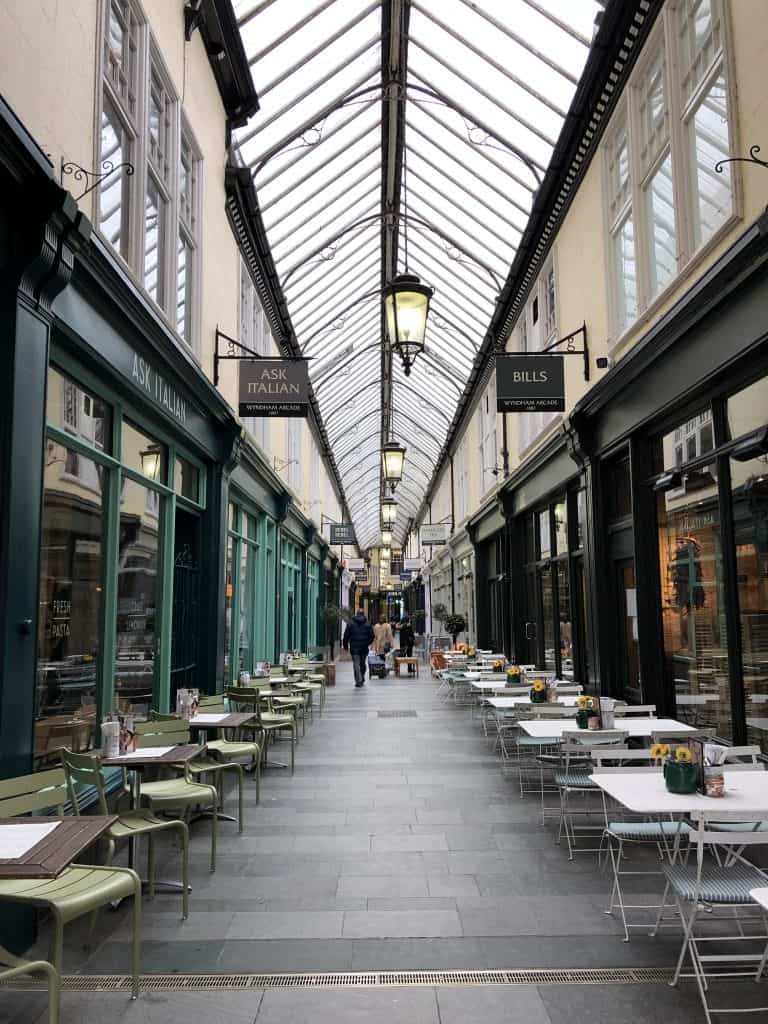 A Victorian arcade with tables and chairs in Cardiff, Wales on spring break.