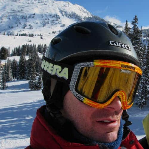 bio photo of Mike Jensen in ski helmet and goggles with mountains in background.