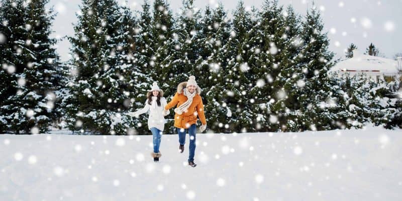 happy couple running in snow