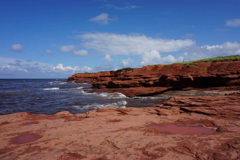 Red stone cliffs along Atlantic Ocean in Prince Edward Island National Park.