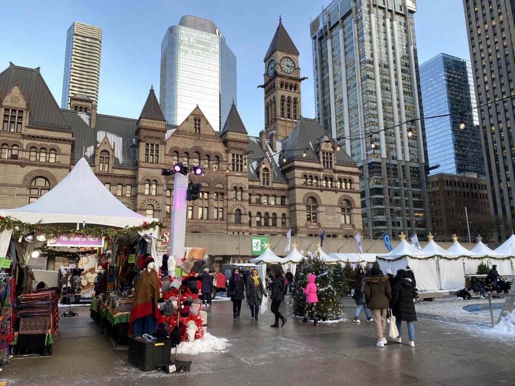 Winter market set up at Nathan Phillips Square in Toronto with Old City Hall and office towers in background.