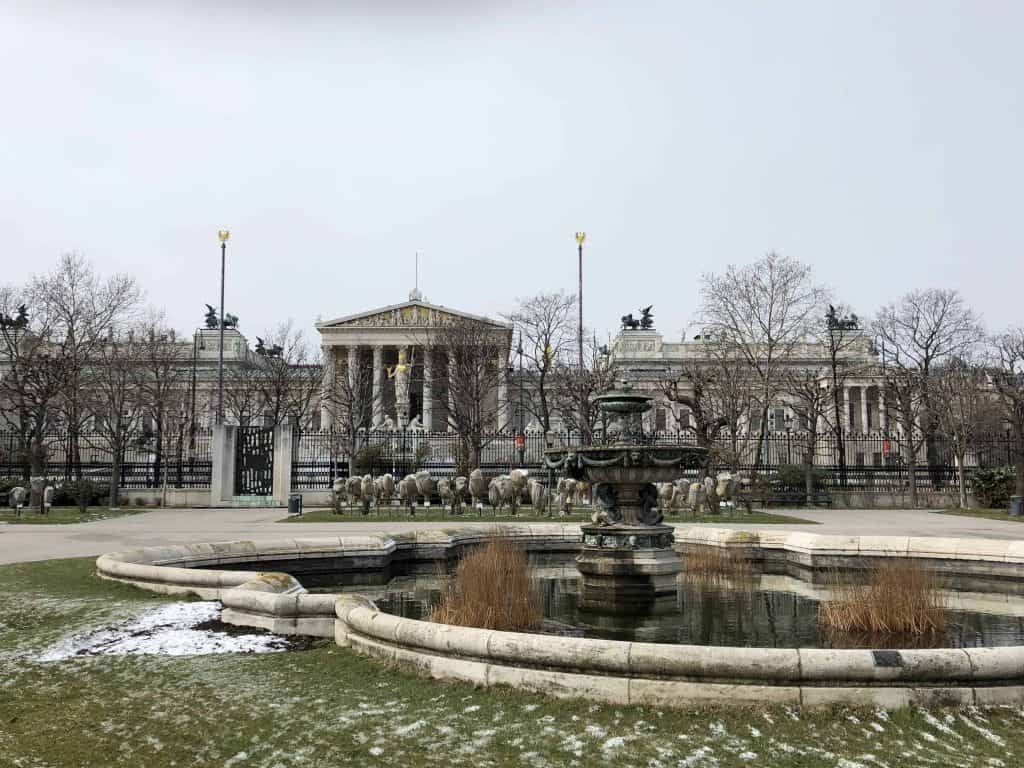 fountains and buildings with light snow on ground-vienna