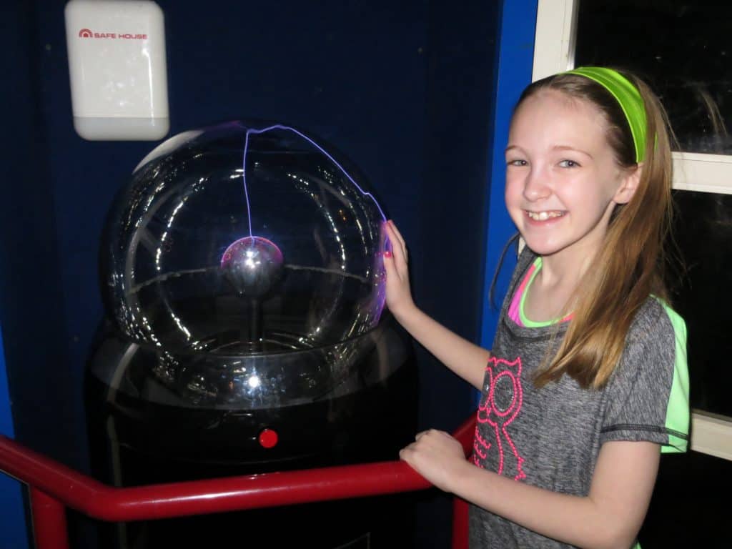 girl at ontario science centre touching plasma ball