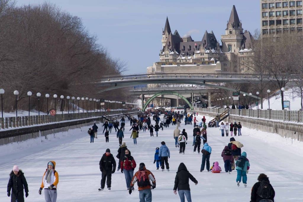 Skaters on the Rideau Canal Skateway in Ottawa with Chateau Laurier in the background.