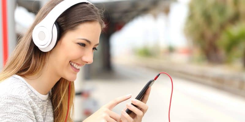 woman listening to music on phone with headphones