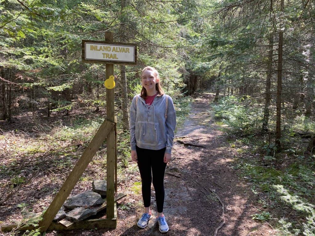Young woman hiking in forest at misery bay provincial park on manitoulin island.