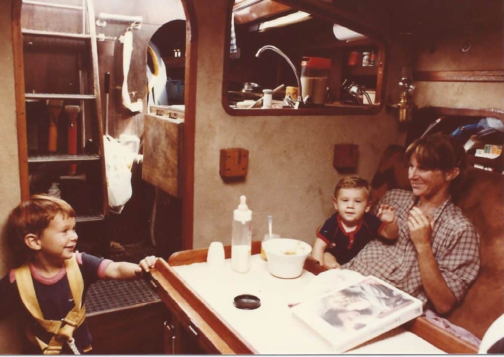 woman and two boys in cabin of sailboat