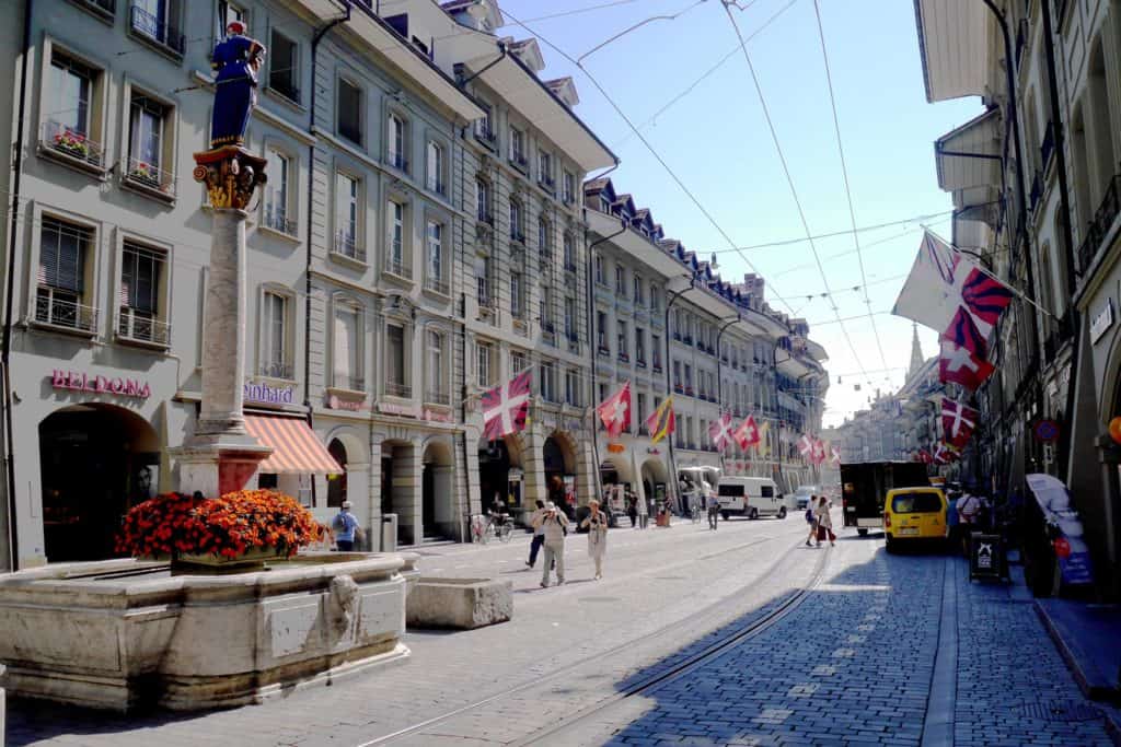 berne, switzerland old town on a spring day with swiss flags decorating street.