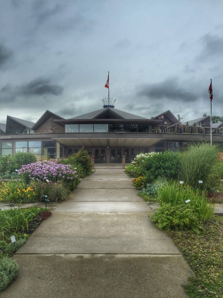 Path through flower gardens to entrance of Festival Theatre in Stratford, Ontario on a cloudy day.