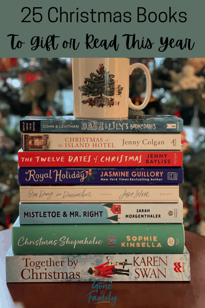 Pinterest Image - stack of books with Christmas mug sitting on top in front of Christmas tree with text overlay reading 25 Christmas Books To Gift or Read This Year.