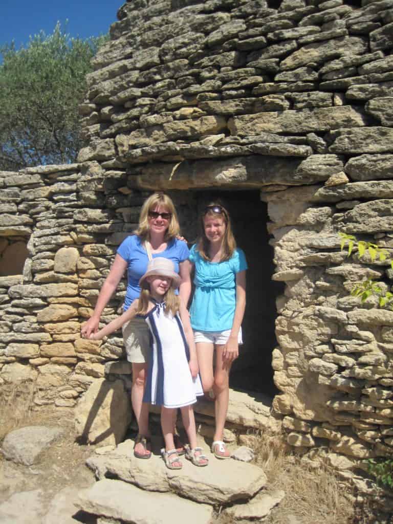 Woman, teen girl and younger girl posing in front of borie structure at Village des Bories.